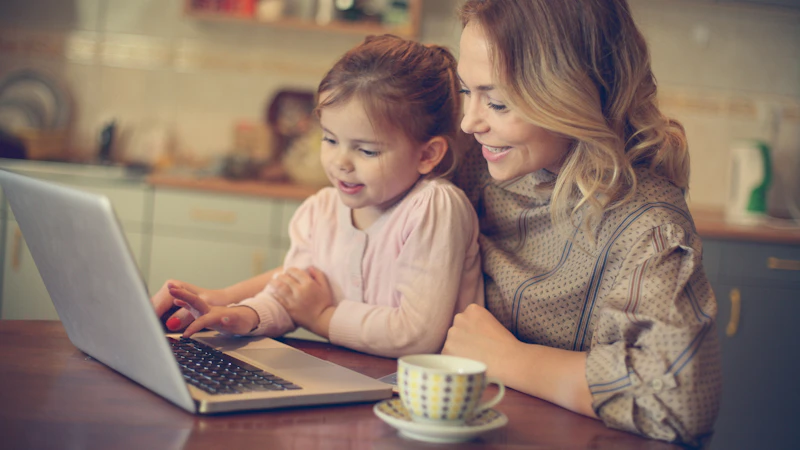 Mama z córką przeglądają oferty kursów na laptopie