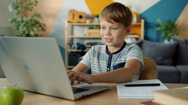 Chłopiec uczy się online przy laptopie